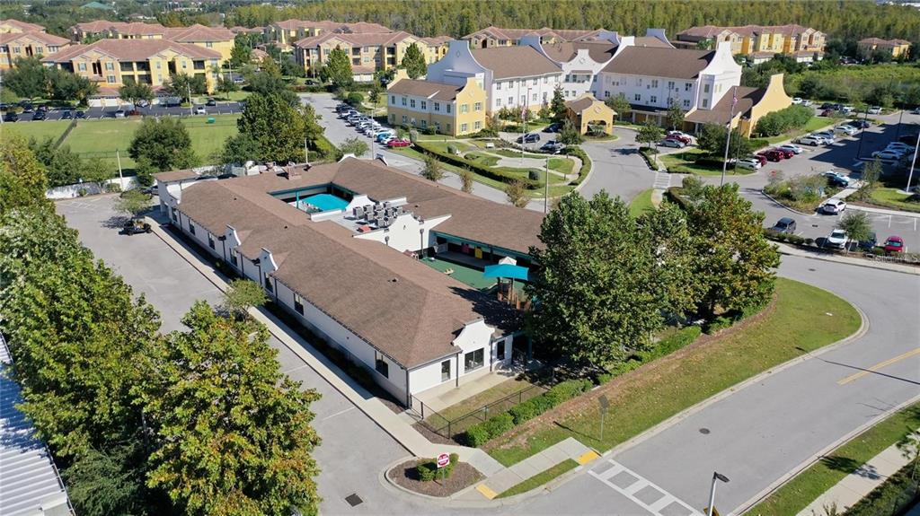 An aerial view shows a low-rise commercial building with a central courtyard and playground — 10911 FOX WOOD COMMERCE DRIVE, NEW PORT RICHEY, FL