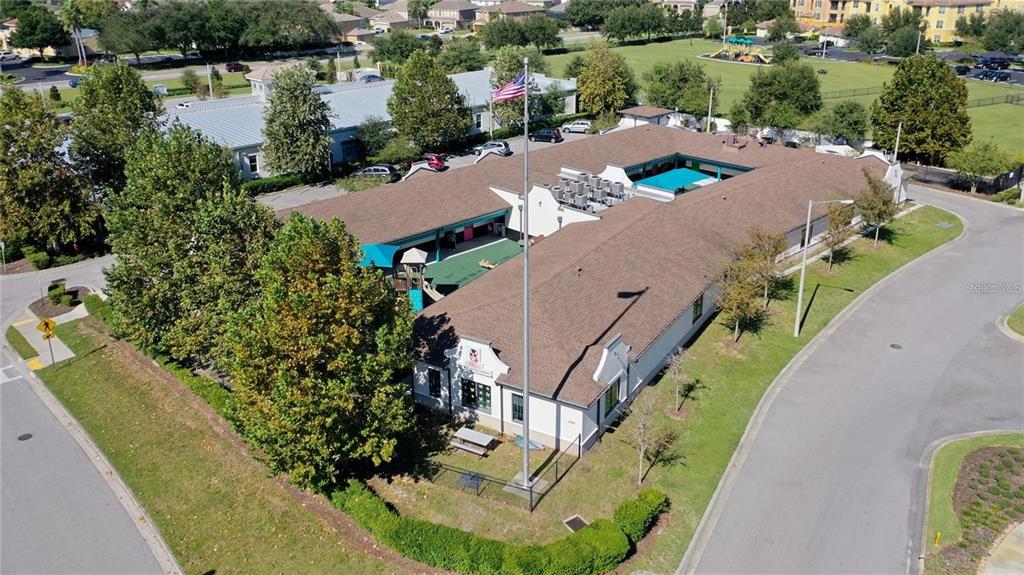 An aerial view shows a single-story commercial building with a central courtyard and flagpole — 10911 FOX WOOD COMMERCE DRIVE, NEW PORT RICHEY, FL