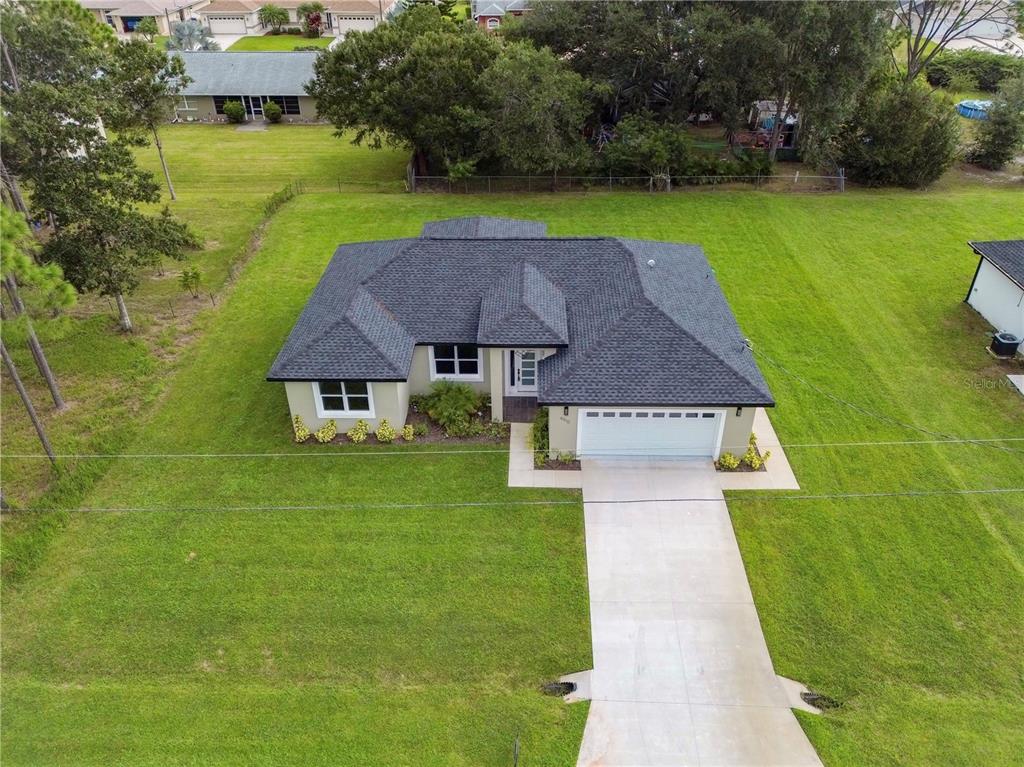 An aerial view shows a single-story house with a dark shingled roof and concrete driveway — 4510 BOABADILLA AVENUE, SEBRING, FL