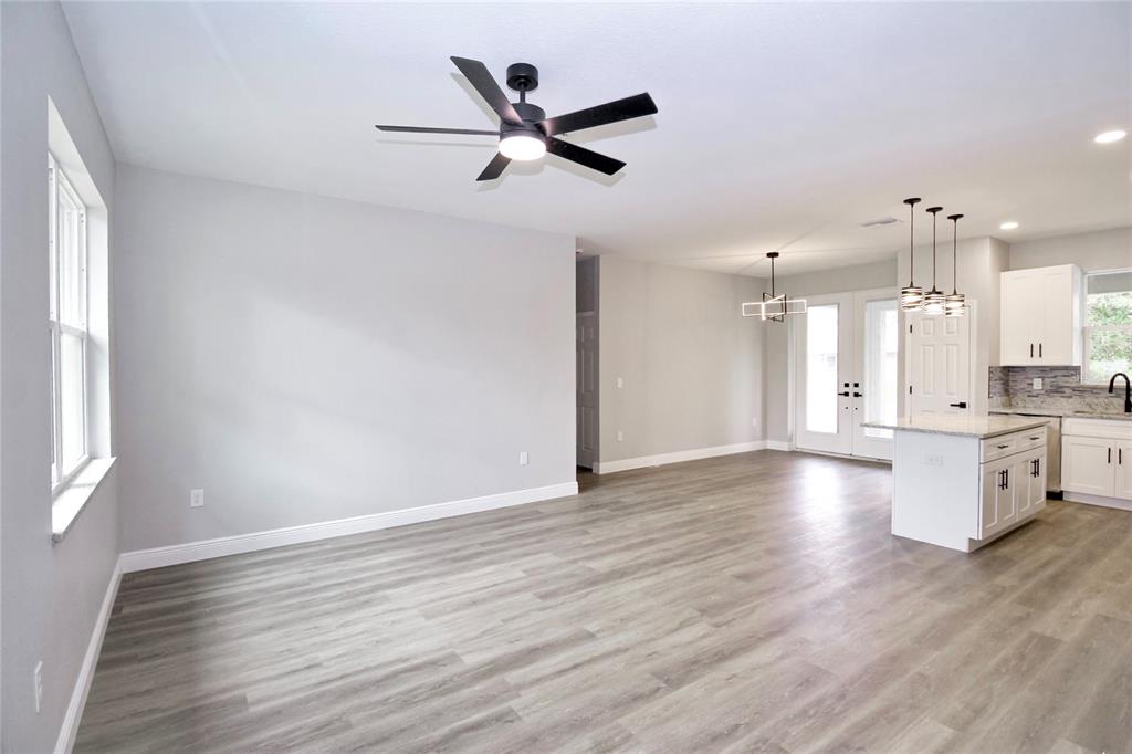 An open-concept living and dining area features light gray walls, wood-look flooring, and a kitchen — 4510 BOABADILLA AVENUE, SEBRING, FL