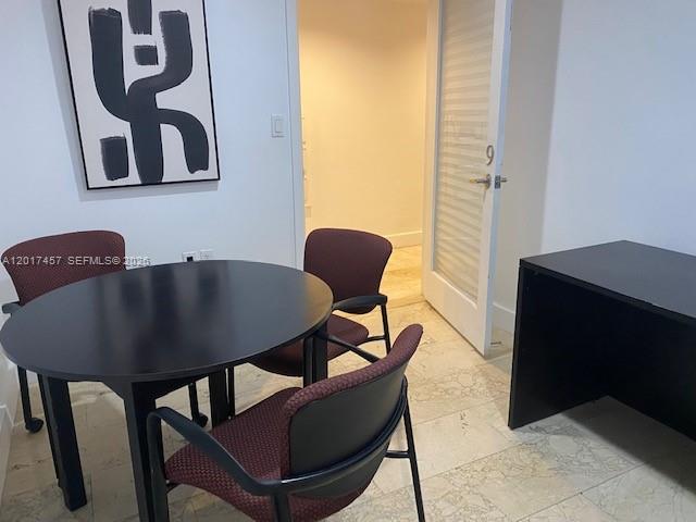 A small office space features a round black table, three chairs, and a desk — SWEETWATER, FL
