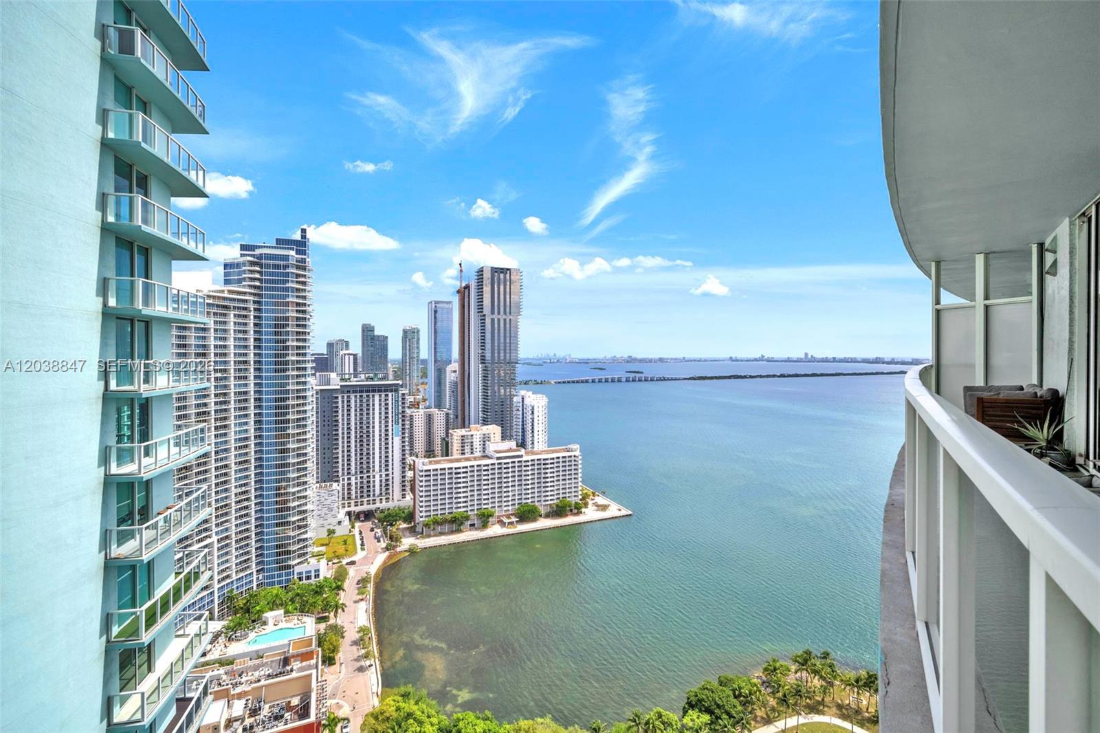 A high-rise balcony overlooks a bay and a dense city skyline on a sunny day — 1900 N Bayshore Dr # 3610, Miami FL 33132, MIAMI, FL