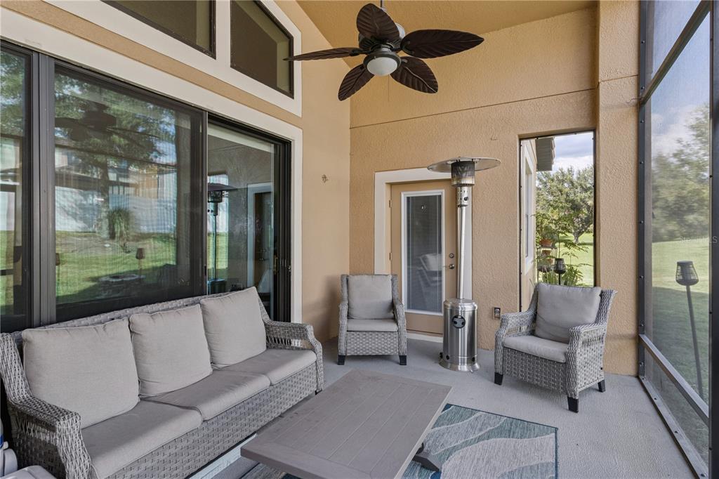 A view from a hallway looking into a kitchen with glass shelves and a living area — 3943 SUNSET LAKE DRIVE, LAKELAND, FL