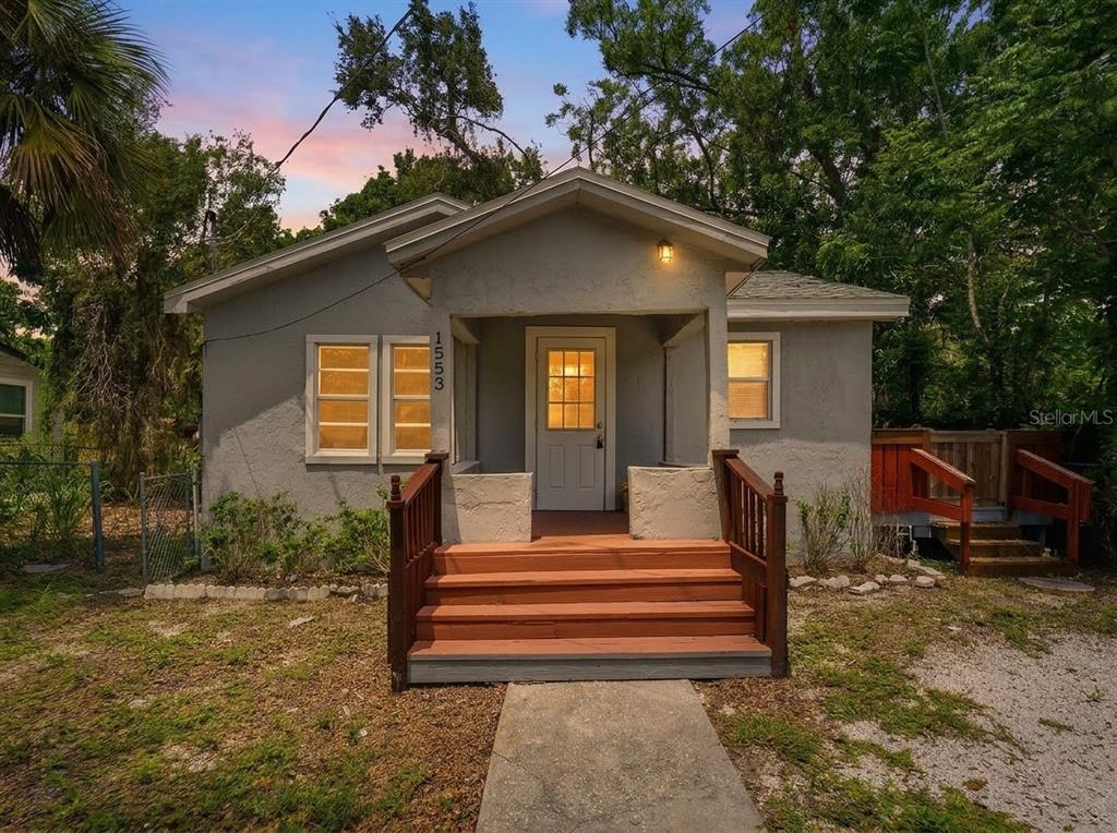 A small, gray, single-story house with a wooden front porch and steps — 1553 29TH STREET, SARASOTA, FL
