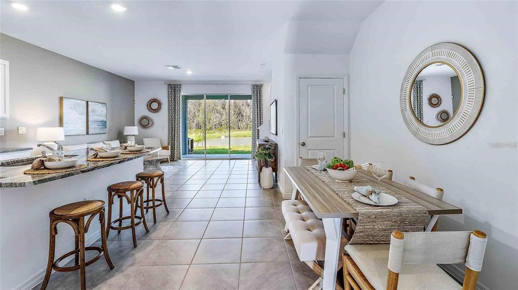 A dining area and kitchen breakfast bar feature tile flooring and a view of nature — 32311 TURTLE GRACE LOOP, WESLEY CHAPEL, FL