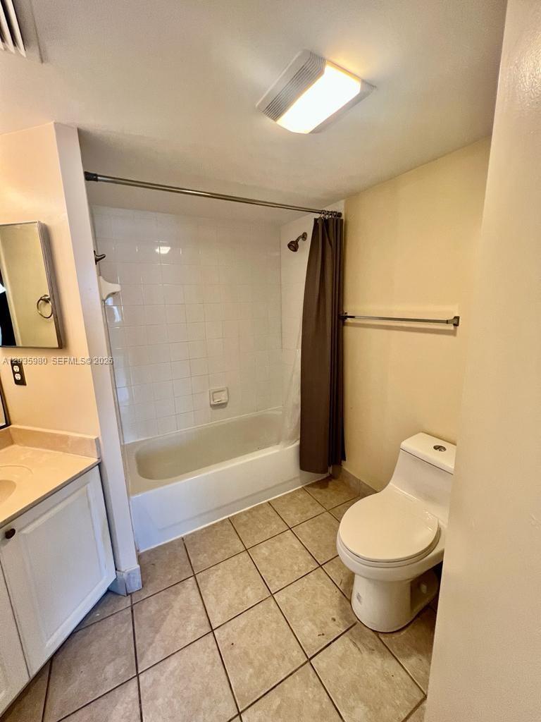 A bathroom features a tiled floor, a white vanity, a toilet, and a shower-tub combination — ROYAL PALM BEACH, FL