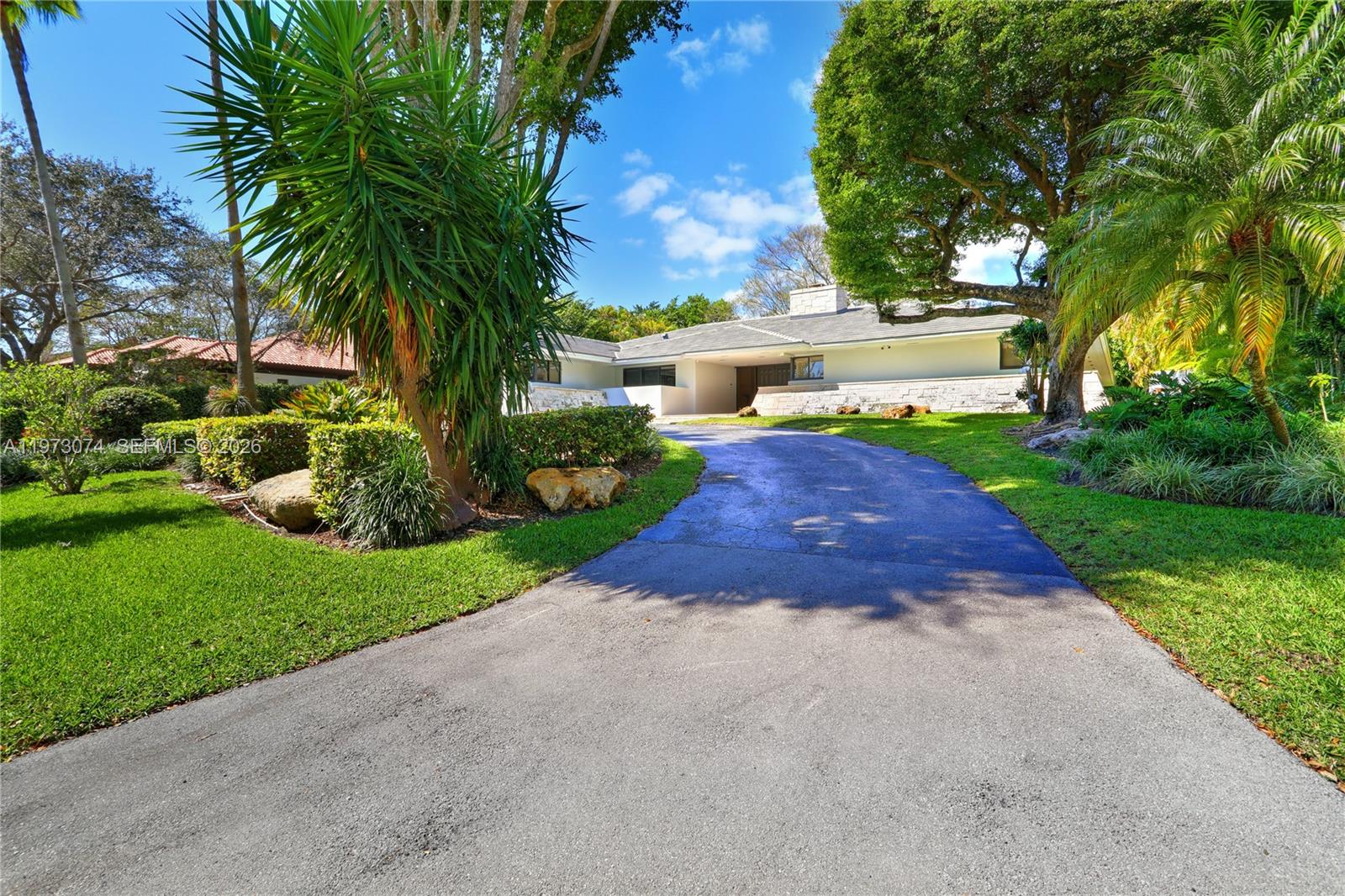 A paved driveway leads to a single-story house surrounded by lush trees and landscaping — 7322 Vistalmar St, Coral Gables FL 33143, CORAL GABLES, FL