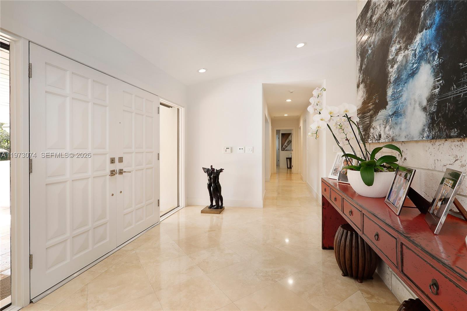 A bright foyer features white double doors, light tile flooring, and a red console table — 7322 Vistalmar St, Coral Gables FL 33143, CORAL GABLES, FL