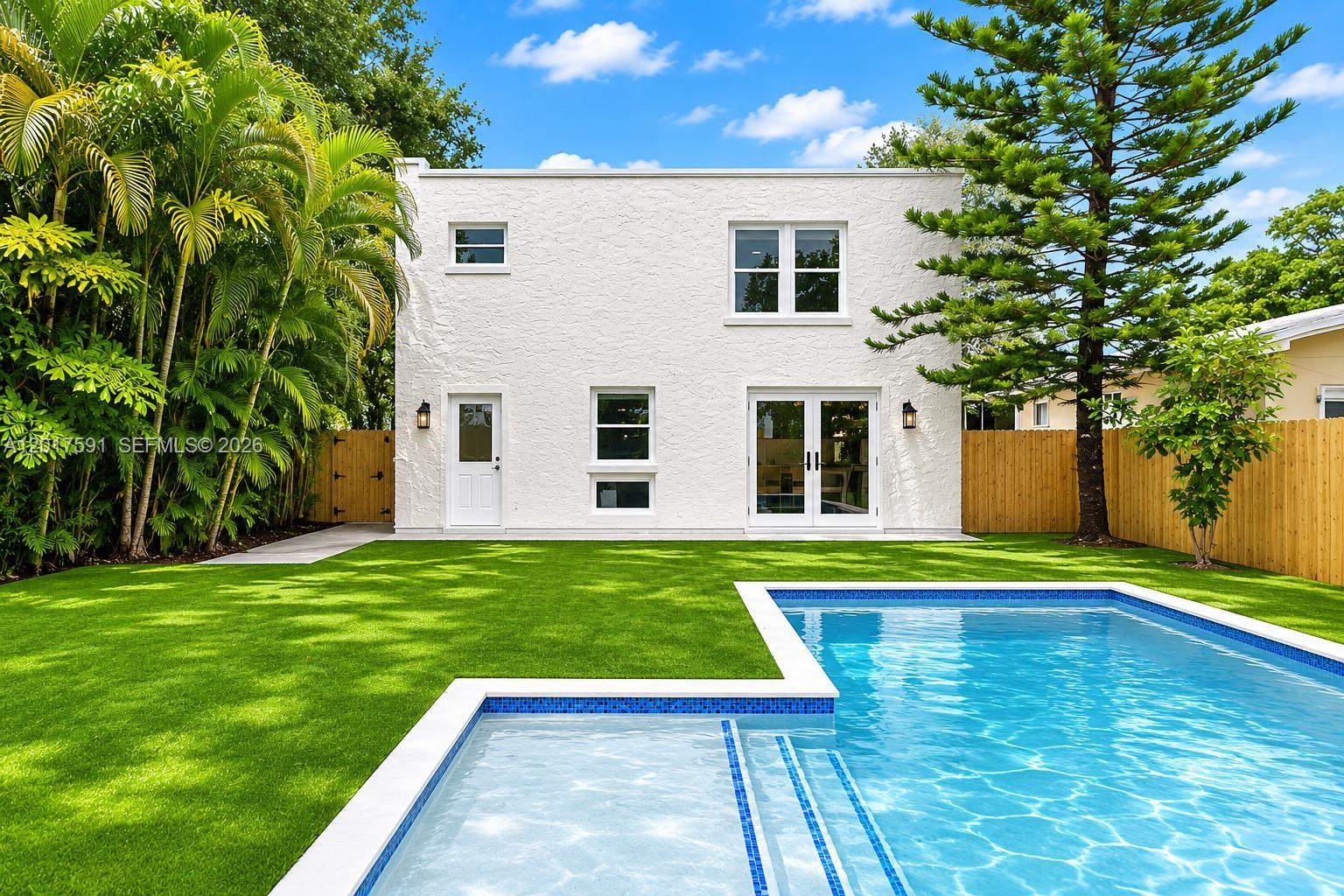 A white two-story house with a backyard pool and artificial turf lawn — 22 NE 44th St, Miami FL 33137, MIAMI, FL