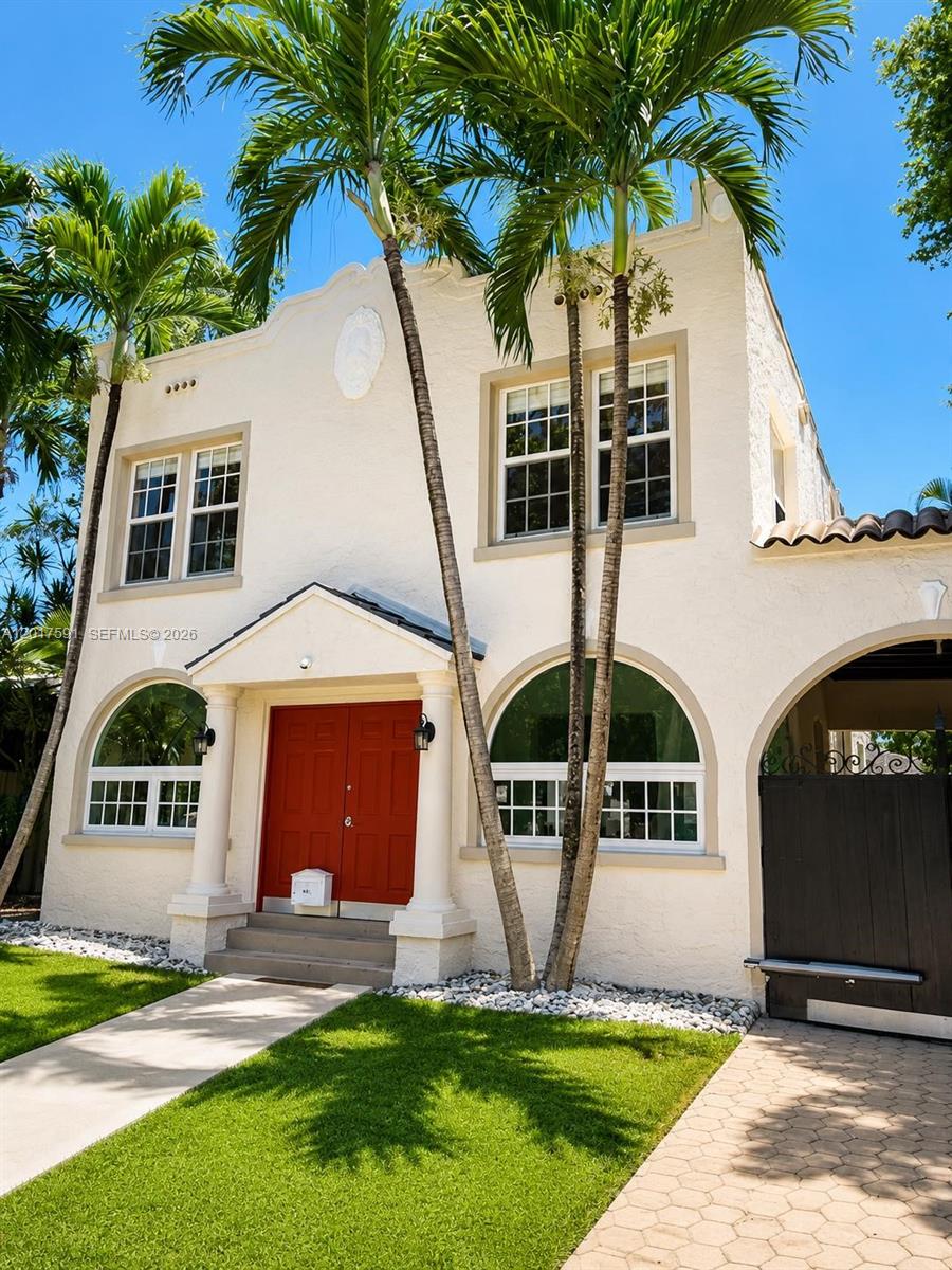 The exterior of a two-story stucco house features a red double door and palm trees — 22 NE 44th St, Miami FL 33137, MIAMI, FL