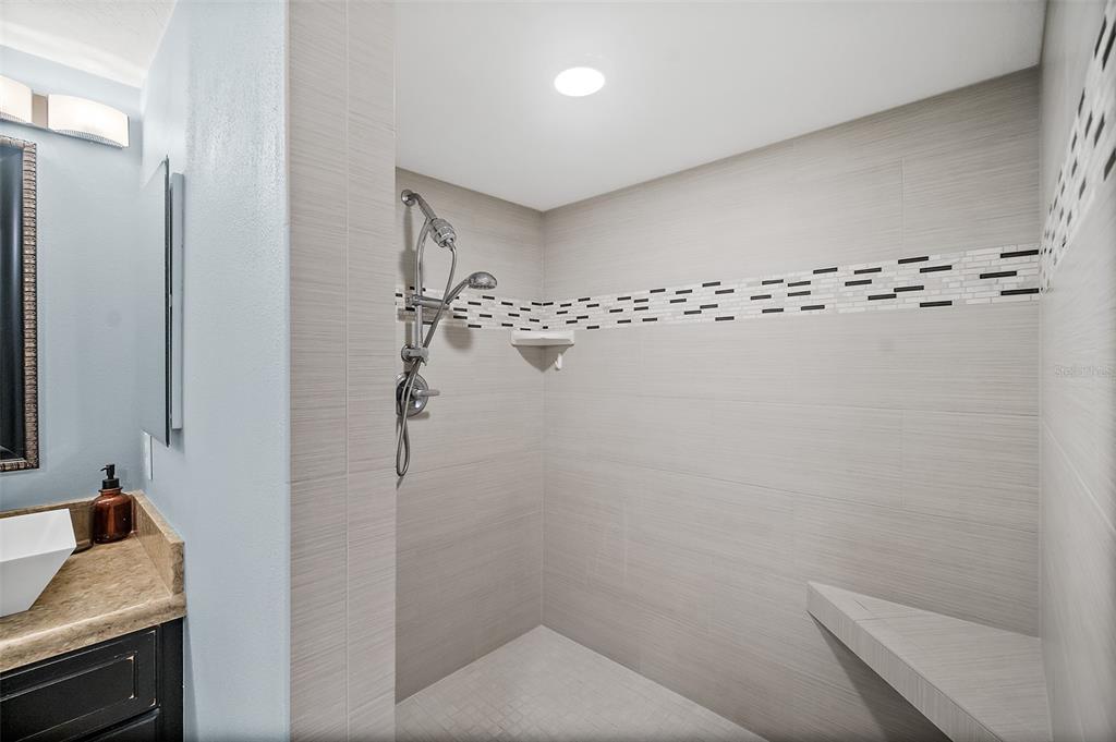 A living room features hardwood floors, a beige sofa, and a balcony overlooking the ocean — 3145 S ATLANTIC AVENUE UNIT 504, DAYTONA BEACH SHORES, FL