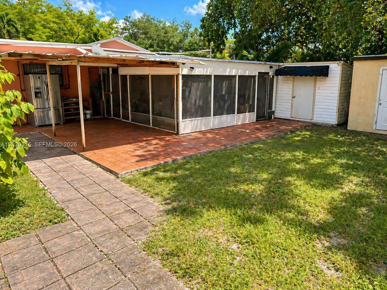 A backyard features a tiled patio, a screened-in porch, and a small white storage shed — 610 SW 66th Ave, Miami FL 33144, MIAMI, FL