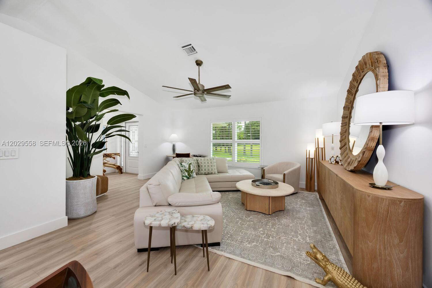 The front entrance features a bright blue door, stone pillar, and potted plants on gravel — 17107 N 84th Ct N, Loxahatchee FL 33470, LOXAHATCHEE, FL