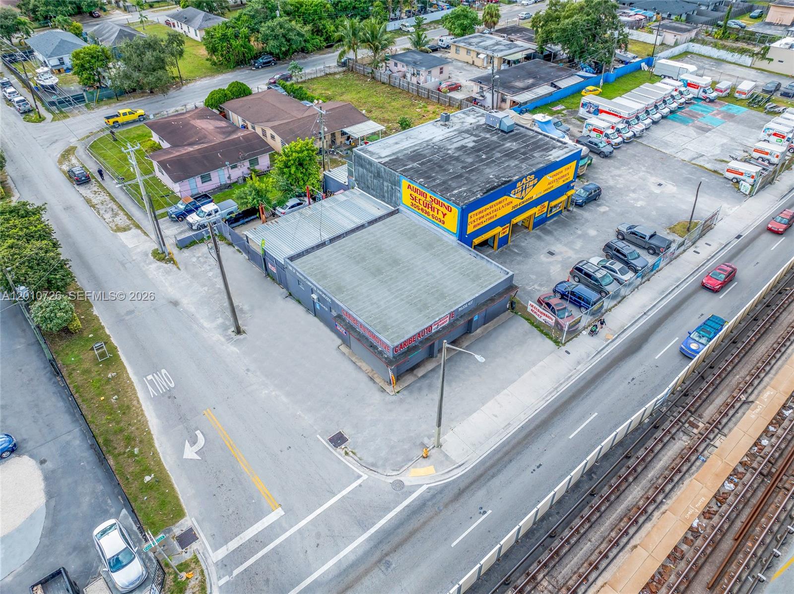An aerial view shows two commercial buildings with parking lots next to a railroad track — 3000 NW 79th St, Miami FL 33147, MIAMI, FL