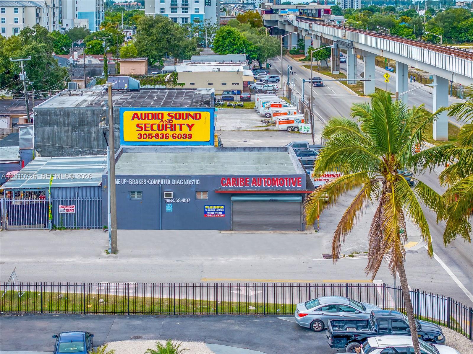 An aerial view shows an automotive repair shop with a large yellow sign and palm tree — 3000 NW 79th St, Miami FL 33147, MIAMI, FL