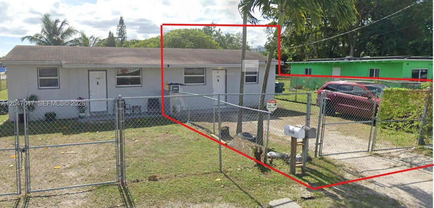 A single-story house with a chain-link fence and a red car parked in the driveway — 11752 SW 212th St # 0, Miami FL 33177, MIAMI, FL
