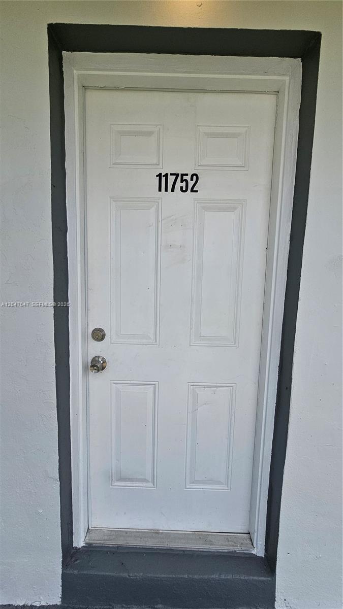 A white exterior door with the number 11752 is set within a dark-trimmed frame — 11752 SW 212th St # 0, Miami FL 33177, MIAMI, FL