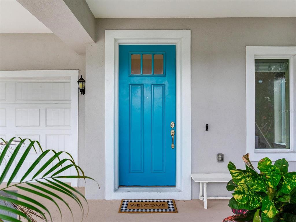 A bright blue front door with a window sits between a garage and a window — 3204 W LEMON STREET, TAMPA, FL