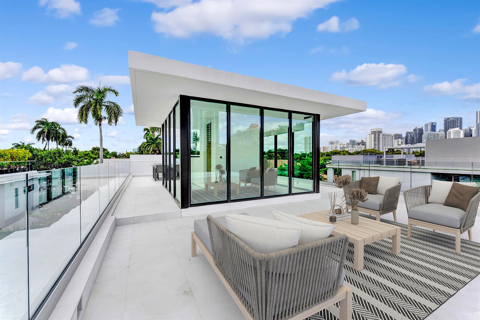 A modern rooftop terrace features a glass-walled structure, outdoor seating, and a city skyline view — 2130 S Miami Avenue, Miami FL 33129, MIAMI, FL