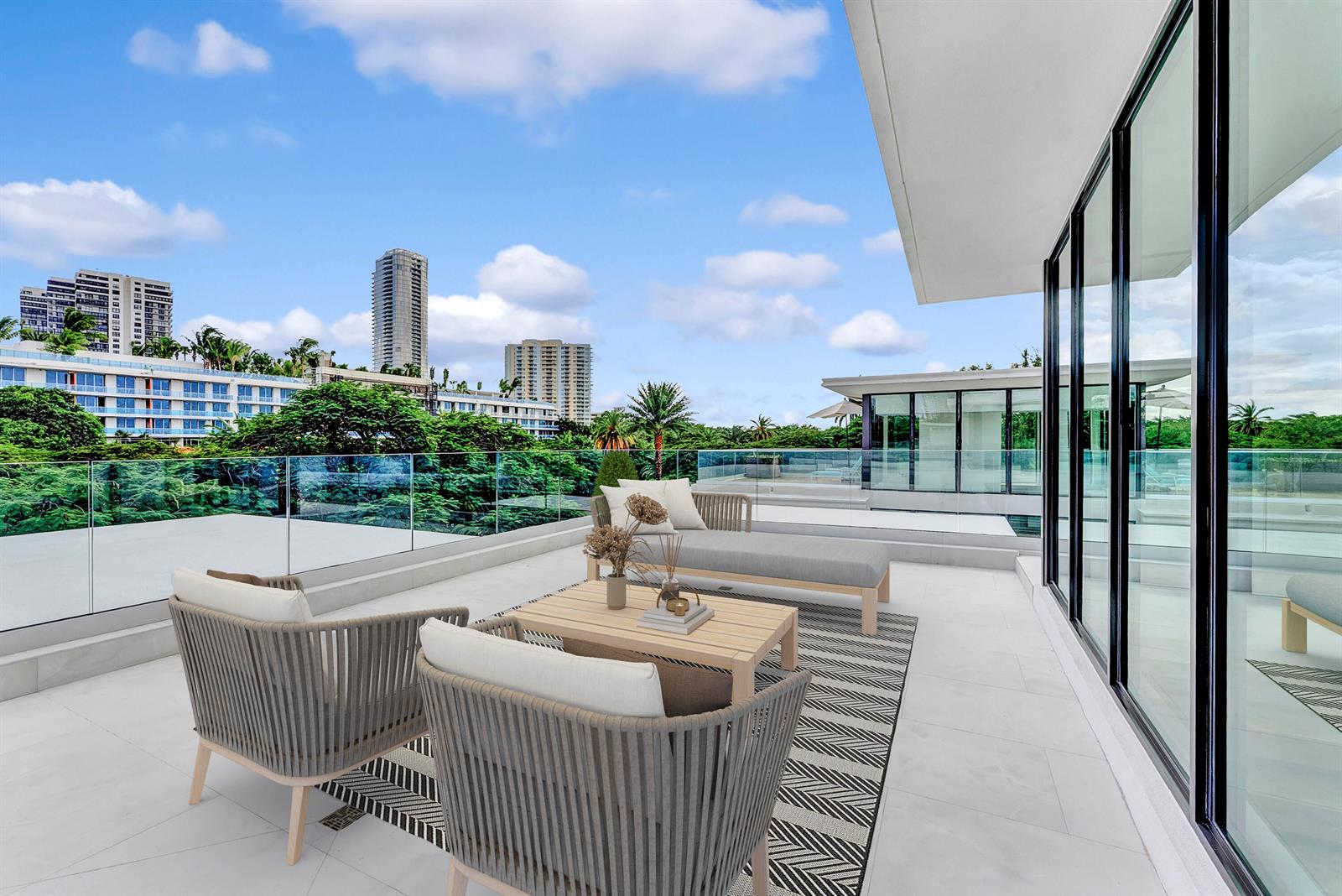 A modern outdoor terrace features lounge chairs, a coffee table, and glass railings overlooking city buildings — 2130 S Miami Avenue, Miami FL 33129, MIAMI, FL