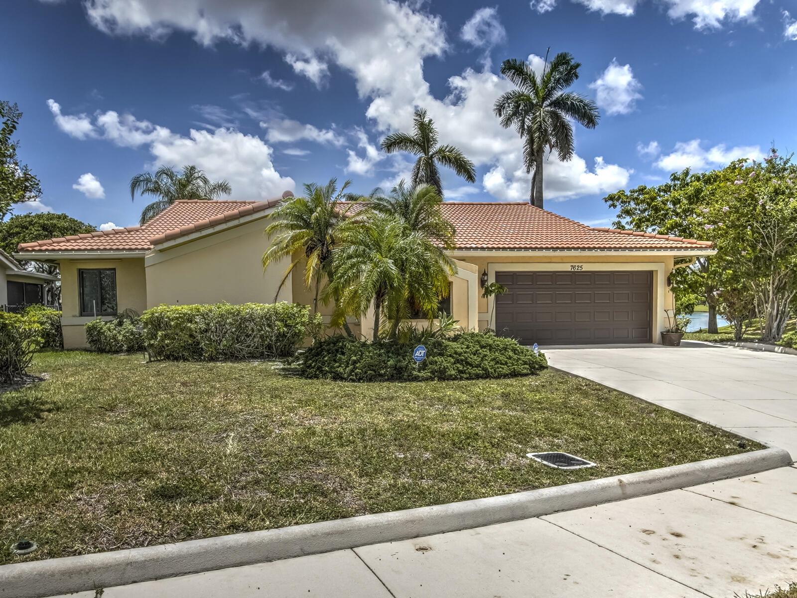 A single-story house with a tile roof, palm trees, and a two-car garage — 7625 Sunflower Drive, Margate FL 33063, MARGATE, FL