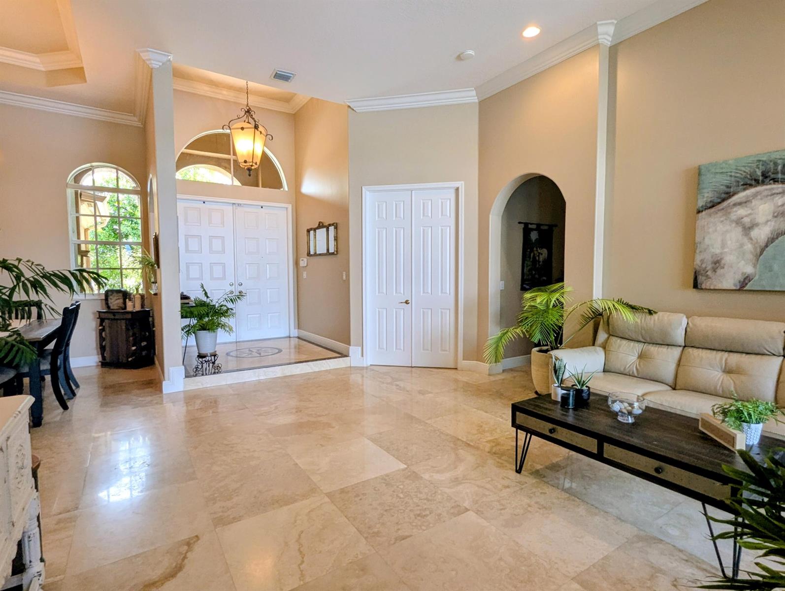 A spacious foyer and living area feature light-colored tile floors, arched doorways, and double doors — 10640 Oak Meadow Lane, Lake Worth FL 33449, LAKE WORTH, FL
