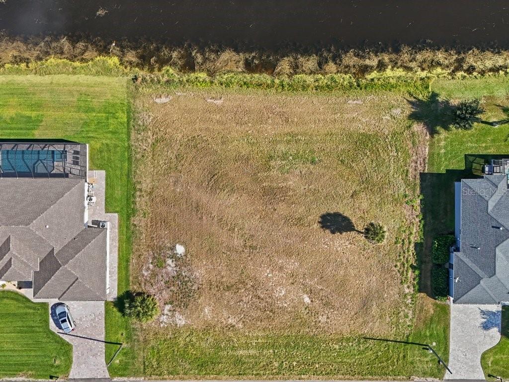 An aerial view shows a vacant rectangular residential lot situated between two existing houses — 176 W PINE VALLEY LANE, ROTONDA WEST, FL