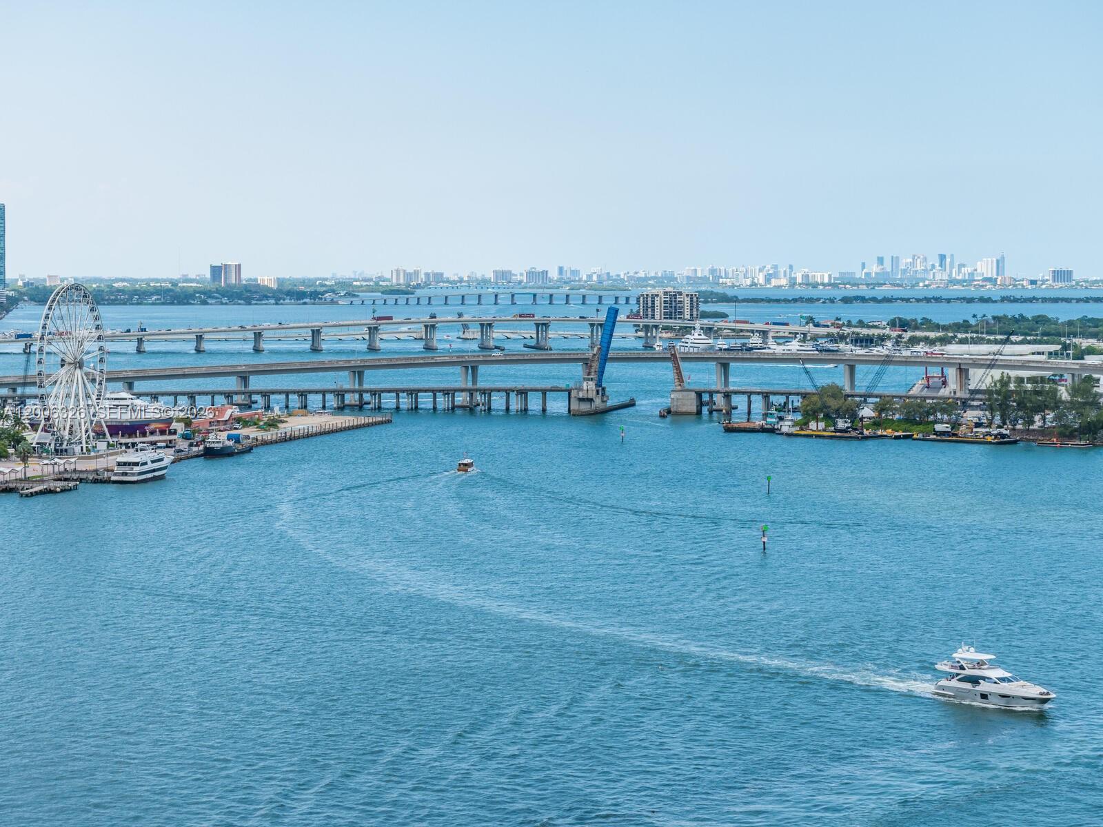 An aerial view shows a bridge, a Ferris wheel, and boats on the water — 888 Brickell Key Dr # 2112, Miami FL 33131, MIAMI, FL
