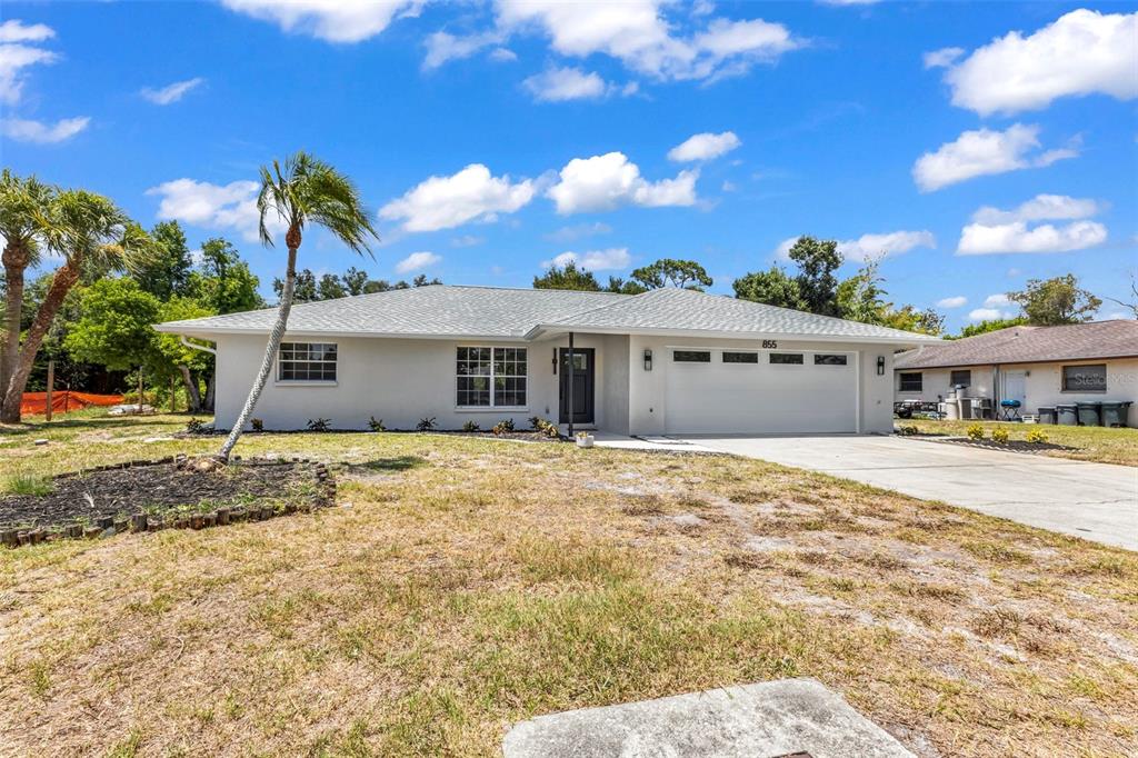 A single-story house with a white exterior, a two-car garage, and a palm tree — 855 MORNINGSIDE ROAD, VENICE, FL