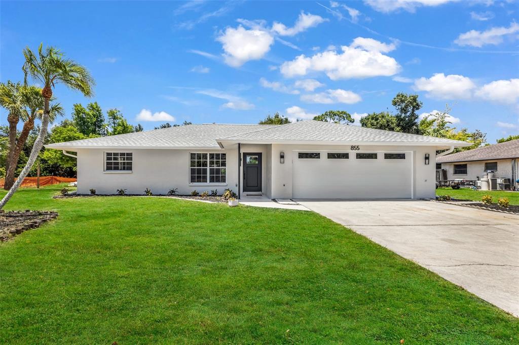 A single-story house with a white exterior, a two-car garage, and a green lawn — 855 MORNINGSIDE ROAD, VENICE, FL