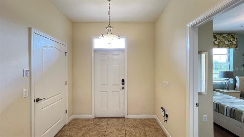 An entryway features a white front door, tile flooring, and a hanging light fixture — 2353 VICTORIA DRIVE, DAVENPORT, FL