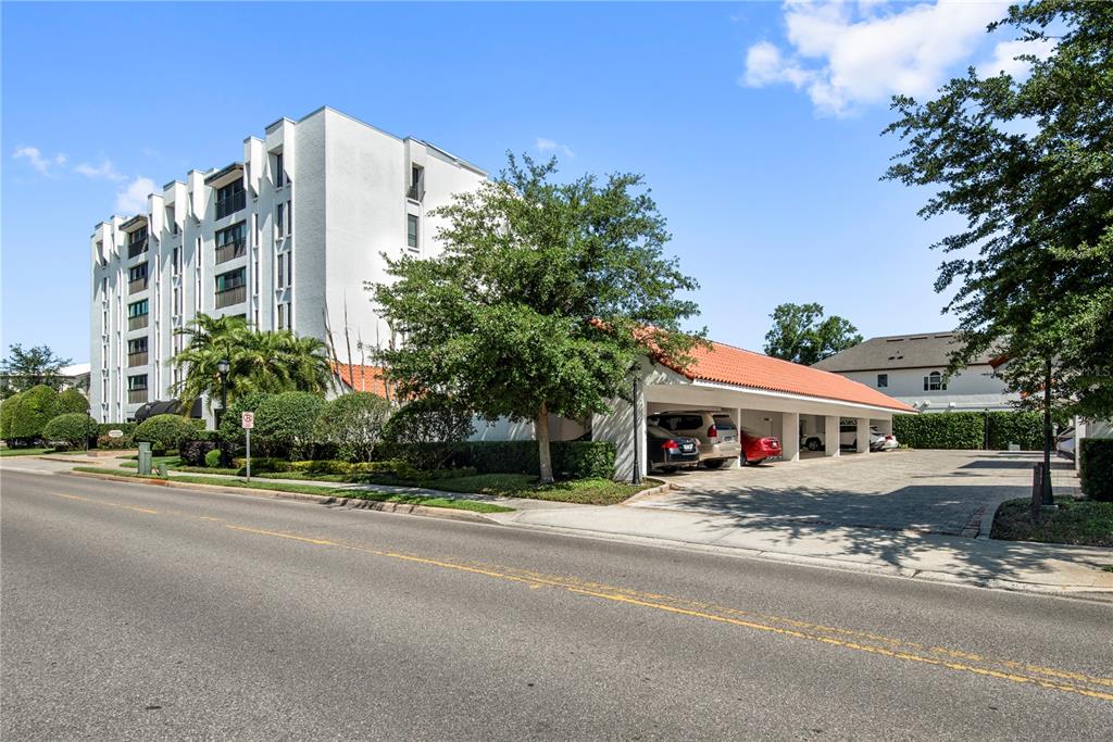 A white multi-story apartment building features a covered parking area with a red-tiled roof — 269 E CANTON AVENUE UNIT 269, WINTER PARK, FL