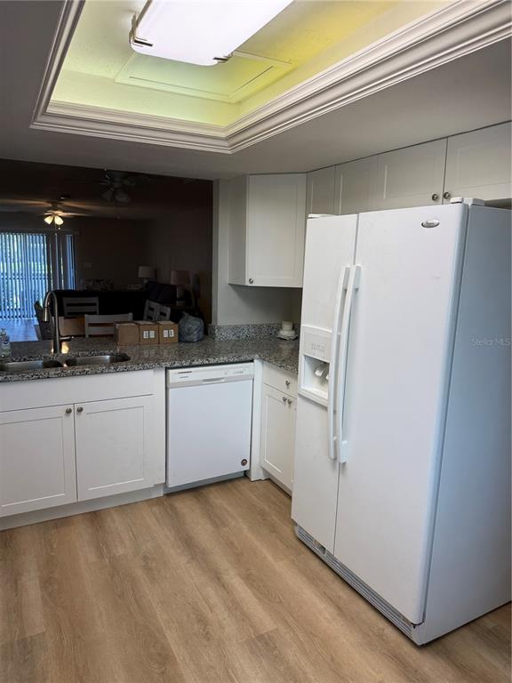 A kitchen features white cabinets, a white refrigerator, a dishwasher, and a recessed ceiling light — 4711 SANTA BARBARA BOULEVARD UNIT 1, CAPE CORAL, FL