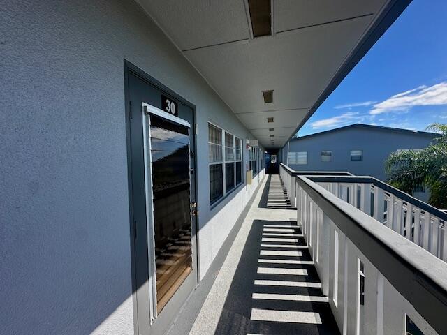 An outdoor walkway with a door labeled 30, white railings, and a view of another building — 30 Suffolk A, Boca Raton FL 33434, BOCA RATON, FL