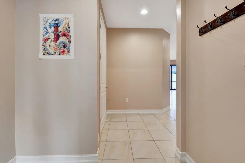 A tiled entryway features a lighthouse painting on the wall and a coat rack — 10102 Akenside Drive, Boca Raton FL 33428, BOCA RATON, FL