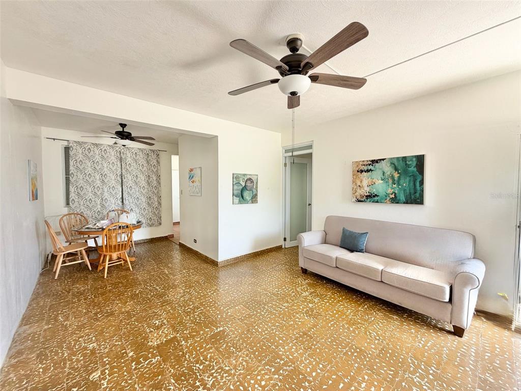 A living room and dining area feature light-colored walls, a beige sofa, and patterned flooring — 139 L STREET RAMEY BASE, AGUADILLA, PR