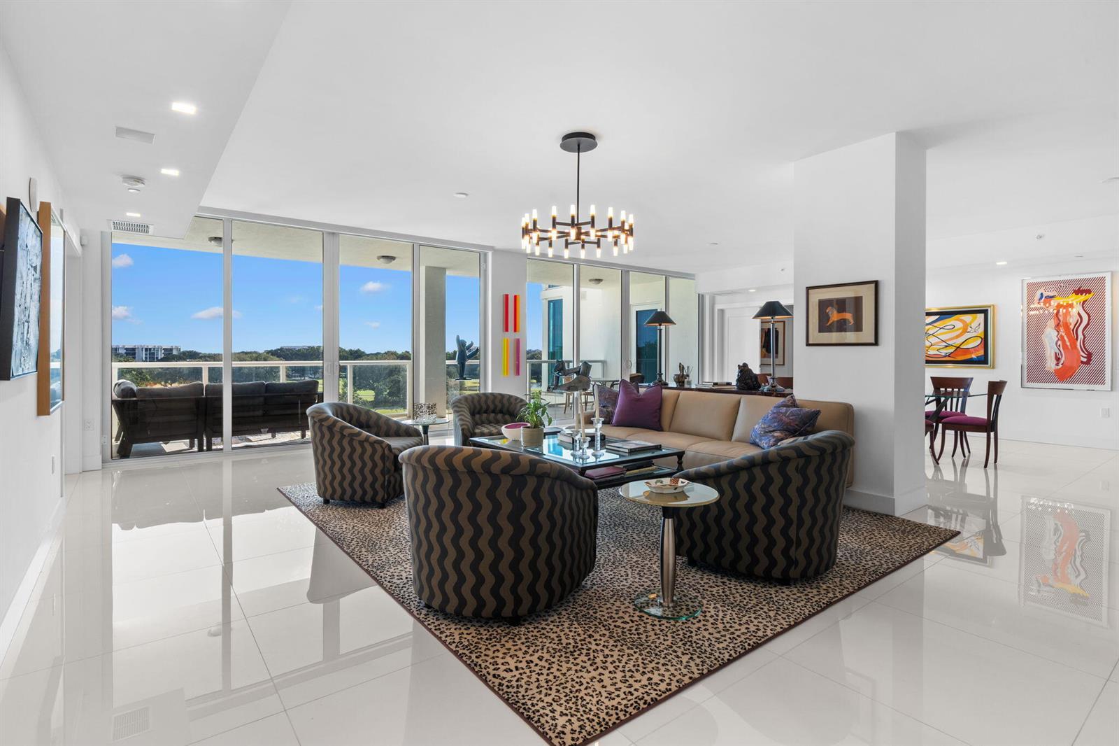 A modern living room features a leopard-print rug, patterned armchairs, and floor-to-ceiling windows — 20155 Boca West Drive # A404, Boca Raton FL 33434, BOCA RATON, FL