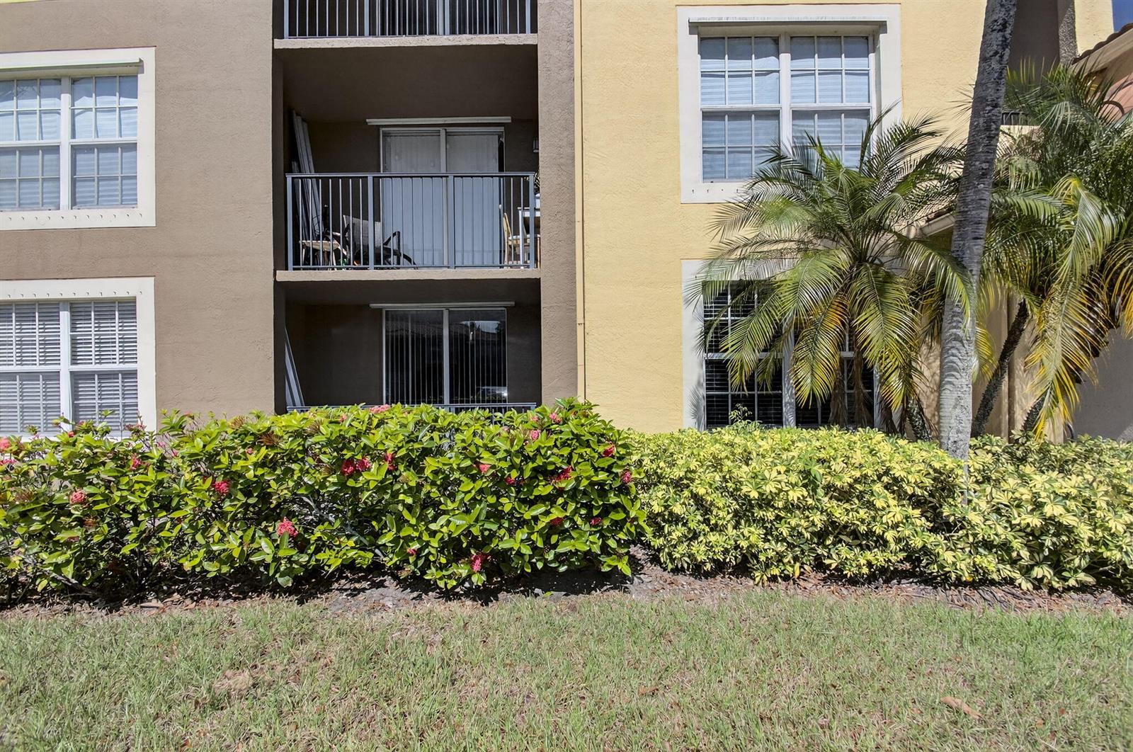 Exterior view of a multi-story apartment building with balconies, windows, and landscaping — 15035 Michelangelo Boulevard # 105, Delray Beach FL 33446, DELRAY BEACH, FL