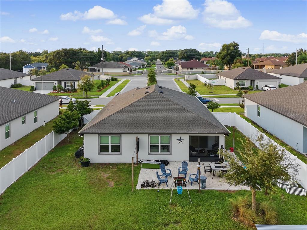 An aerial view of the backyard of a single-story house with a patio — 1067 MICHELANGELO LANE, WINTER HAVEN, FL