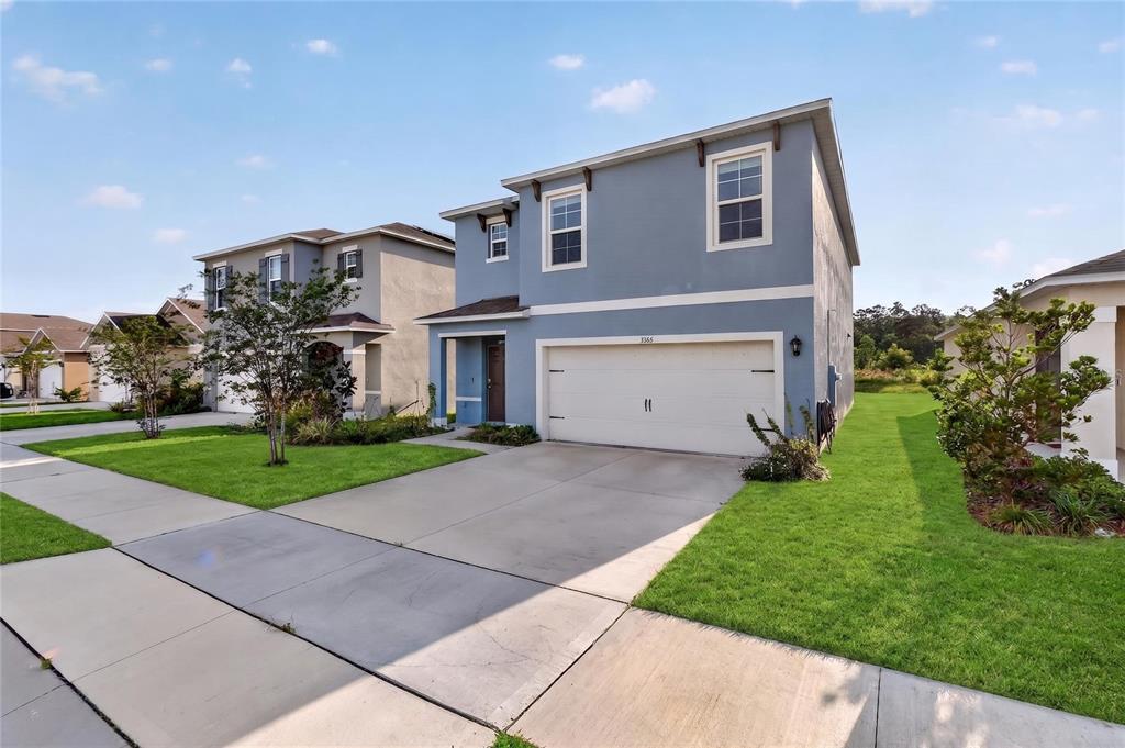 A two-story blue house with a two-car garage and a concrete driveway — 3365 COSTELLO CIRCLE, WINTER HAVEN, FL