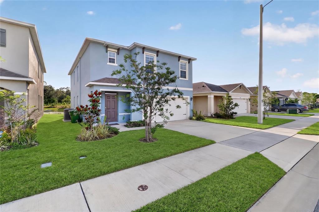 A two-story blue house with a two-car garage and a front yard lawn — 3365 COSTELLO CIRCLE, WINTER HAVEN, FL