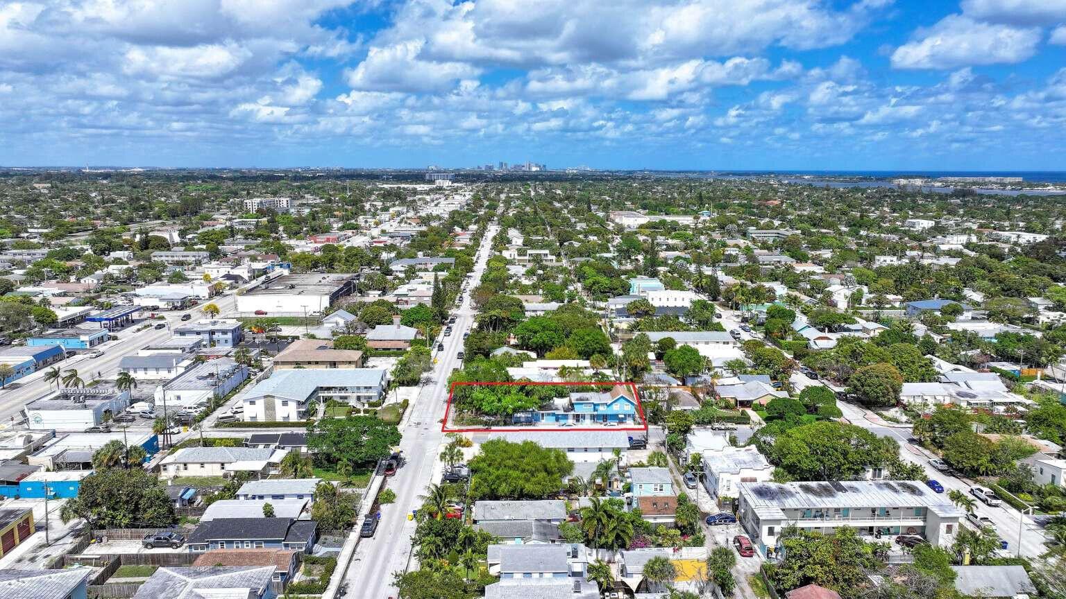 An aerial view shows a blue house outlined in red amidst a suburban neighborhood — 714 N 4th Ave Avenue N, FL 33460, FL