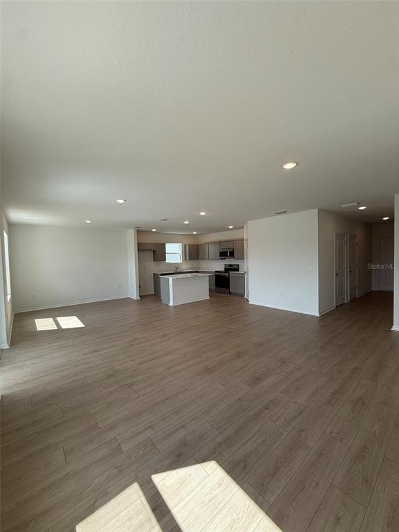 An open-concept kitchen with a central island and light wood flooring — 13045 SASSAFRAS TRAIL, PARRISH, FL