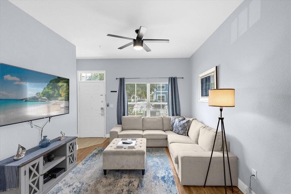 A living room features a sectional sofa, a television, a ceiling fan, and a rug — 2213 SAN VITTORINO CIRCLE UNIT 106, KISSIMMEE, FL