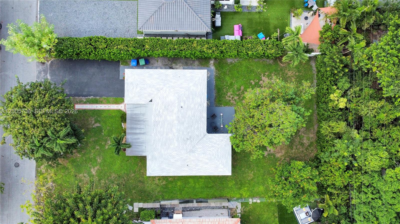 An aerial view shows a house with a light-colored roof surrounded by a grassy yard — 231 NE 43rd St, Miami FL 33137, MIAMI, FL