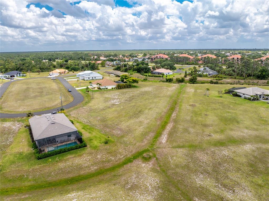 An aerial view shows a residential lot with a house and pool near a road — 17508 & 17514 VELLUM CIRCLE, PUNTA GORDA, FL