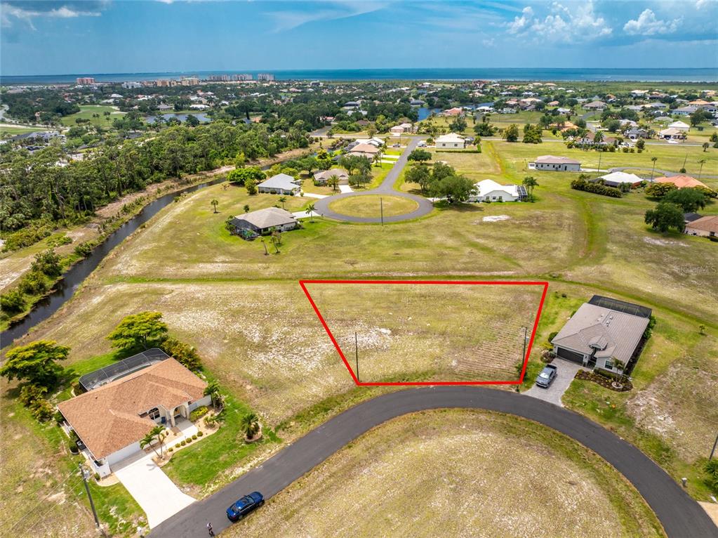 An aerial view shows a vacant, trapezoidal residential lot outlined in red within a neighborhood — 17508 & 17514 VELLUM CIRCLE, PUNTA GORDA, FL