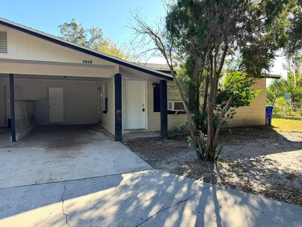 A single-story house with a carport, white front door, and concrete driveway — 1615 N NEW YORK AVENUE, LAKELAND, FL