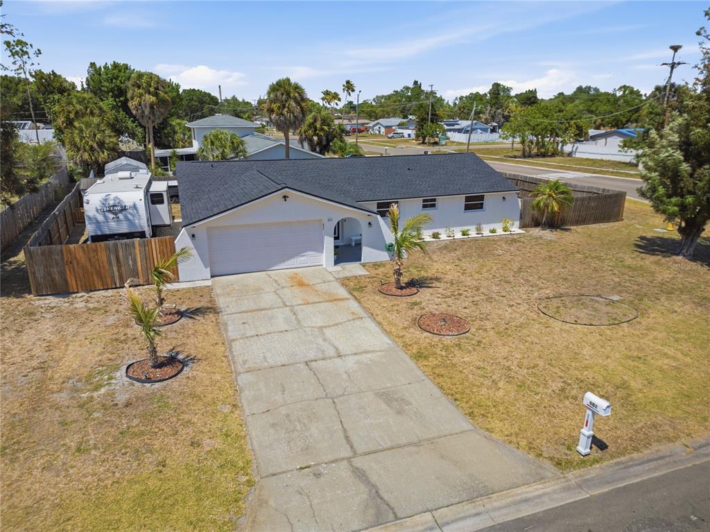 An aerial view of a white single-story house with a black roof and concrete driveway — 601 GOLF AND SEA BOULEVARD, APOLLO BEACH, FL