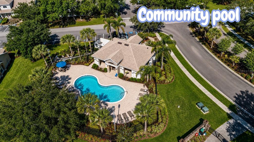 An aerial view shows a community clubhouse with a swimming pool and surrounding landscaping — 14776 LAGUNA BEACH CIRCLE, ORLANDO, FL